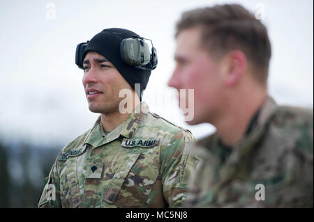 Armee SPC. Arturo Dominguez, ein Eingeborener von Okeechobee, Fla., Charlie Truppe, 1st Squadron, 40th Cavalry Regiment (Airborne), 4 Infantry Brigade Combat Team (Airborne), 25 Infanterie Division, U.S. Army Alaska zugeordnet, hört eine Anweisung vor dem Training mit seinem M 110 Halbautomatische Sniper System auf Statler Strecke am Joint Base Elmendorf-Richardson, Alaska, 6. April 2018, während der Treffsicherheit der Ausbildung. Hauptaufgabe ist ein Sniper ist diskriminierend, hoch präzise Gewehr Feuer gegen feindliche Ziele, die nicht von der regelmäßigen Rifleman durch Auswahl, Größe eingeschaltet werden, Stockfoto
