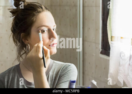 Jugendlicher Mädchen Anwendung Lidschatten ihr Spiegelbild auf einem Spiegel zu Hause suchen. Stockfoto