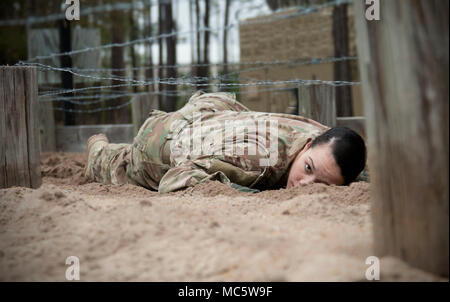 Staff Sgt. Amber Reiter, noncommissioned Officer verantwortlich für die Primäre Gesundheitsversorgung in der Tuttle Armee Gesundheit Klinik, U.S. Army Medical Department Aktivität - Fort Stewart, kriecht unter Stacheldraht während ein Hindernis Kurs am Fort Stewart, Ga, 27. März 2018. Der Parcours war einer von mehreren Veranstaltungen während der regionalen Gesundheit Befehl - Atlantic besten Krieger Wettbewerb. Stockfoto