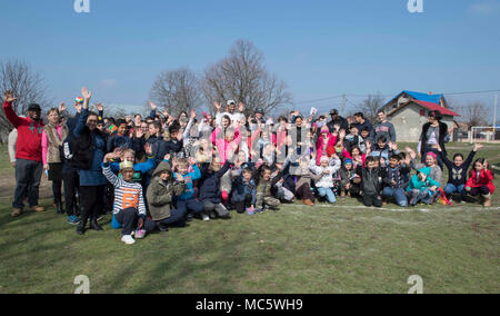 DEVESELU, Rumänien (28. März 2018) Segler und Zivilisten aus Naval Support Facility Deveselu ein Gruppenfoto mit der Schulverwaltung und Kinder aus Deveselu Schule, eine lokale rumänische Schule, während ein Osterei Community Relations (COMREL) Projekt. NSF AAMDS Deveselu und Rumänien sind in Zusammenarbeit mit dem Rumänischen 99th Military Base entfernt und eine wichtige Rolle bei der Abwehr ballistischer Flugkörper in Osteuropa spielen. Stockfoto