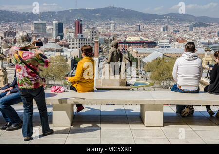 Ein Blick von außen das nationale Kunstmuseum von Katalonien über die Stadt Barcelona. Touristen sitzen auf einer Bank, um die Aussicht zu genießen. Stockfoto