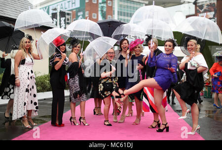 Racegoers Unterschlupf vor dem Regen während der Damen Tag des 2018 Randox Gesundheit Grand National in Aintree Racecourse, Liverpool. Stockfoto