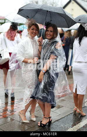 Racegoers Unterschlupf vor dem Regen während der Damen Tag des 2018 Randox Gesundheit Grand National in Aintree Racecourse, Liverpool. Stockfoto