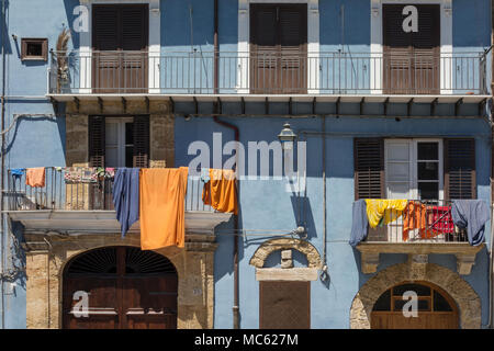 Bunte Wäsche hängen von den Balkonen auf ein Gebäude mit blau lackierten Wände in Palermo, Sizilien, Italien. Stockfoto