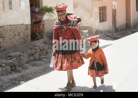 Quechua indischen Frau und ihre Enkelin in bunten Handwoven Outfit gekleidet. Oktober 18, 2012 - Maras, Urubamba Tal, Peru Stockfoto