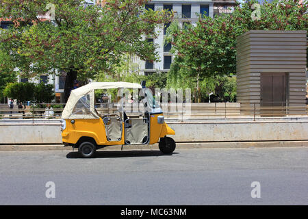 Tuk Tuk kleine Passagier drei weel Mini Auto auf Sommer leere Straße Straße Hintergrund isoliert. Leuchtend gelbe Rikscha durch Einheimische auf der Straße gefahren Stockfoto