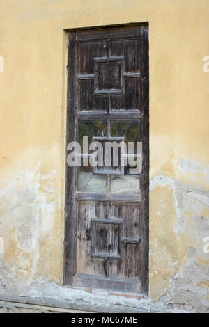 Auf dem Foto ist eine alte schmutzige Tür. Stockfoto