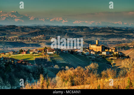 Panorama auf der Langhe mit Castiglione Falletto und seine Burg, weiter hinten die Stadt Diano und, im Hintergrund, der Kreis der Alpen. Stockfoto