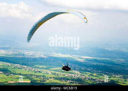 Gleitschirm über die Felder an einem sonnigen Tag fliegen. Polen. Stockfoto