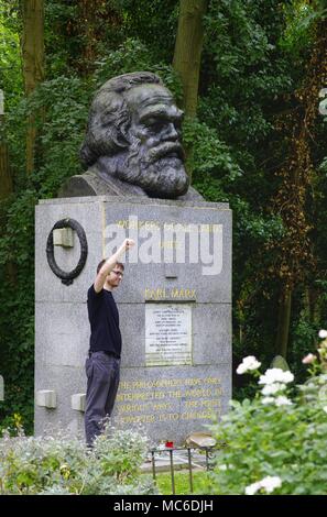 Ein junger Mann steht in den Highgate Cemetery in London mit seiner Faust hob neben der Grabstätte von Karl Marx (1818-1883). Marx wurde vor 200 Jahren geboren am 05.05.1818, in Trier. (13 September 2015) | Verwendung weltweit Stockfoto