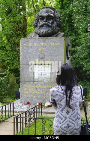 Ein junger Mann steht in den Highgate Cemetery in London mit seiner Faust hob neben der Grabstätte von Karl Marx (1818-1883). Marx wurde vor 200 Jahren geboren am 05.05.1818, in Trier. (13 September 2015) | Verwendung weltweit Stockfoto