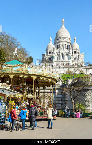 Eine touristische Familie beobachtet die Souvenirs in der Nähe der Karussell in der Louise Michel Park unterhalb der Basilika des Heiligen Herzen von Paris angezeigt. Stockfoto