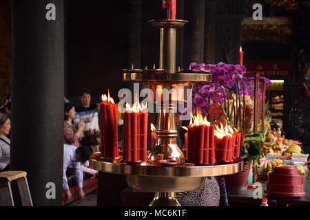 Rote Kerzen mit unscharfen Leute im Hintergrund innen Longhsan buddhistischen Tempel beten in Taipei, Taiwan Stockfoto