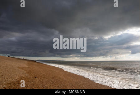 Strand angler angeln am Chesil Beach, nach einem Sturm im Januar 2018. Angeln nach einem Sturm eine produktive Zeit sein kann, für einen Fisch, um zu versuchen Stockfoto