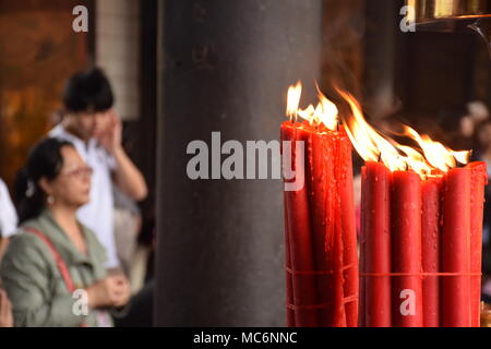 Rote Kerzen mit unscharfen Leute im Hintergrund innen Longhsan buddhistischen Tempel beten in Taipei, Taiwan Stockfoto