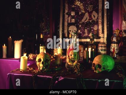 Eine Voodoo Altar mit ventilkegel Flasche, Schädel, Ketten, Flasche - Kerzen und mehrere Altar Bilder. Stockfoto