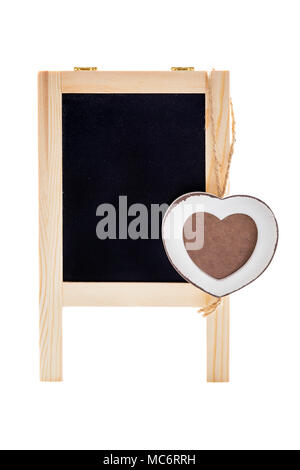 Leere schwarze Kreide Bord mit hölzernen Herzform Rahmen für Foto. Auf weiß isoliert. Stockfoto