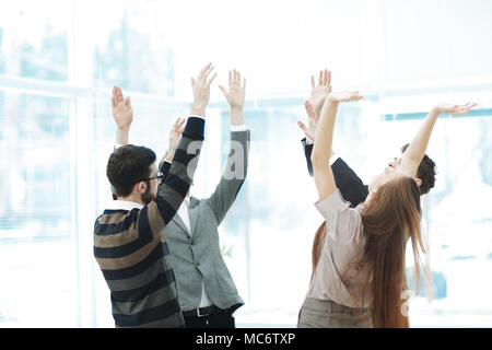 Motivierte junge Business Team Verpfändung Unterstützung heben ihre Hände Stockfoto