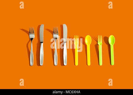 Vier Sätze von Besteck auf orangem Hintergrund, die das Konzept von Familie Stockfoto