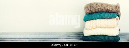 Stapel der gestrickte Wolle Pullover auf weißem Hintergrund mit kopieren. Pullover, Kleidung. Banner. Stockfoto