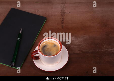 Notebook mit Stift und Kaffee Tasse auf hölzernen Hintergrund, Geschäftskonzept. Stockfoto
