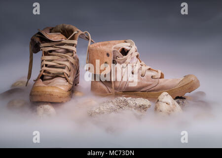 Leichen in Uniform auf Eis Rauch. Der menschliche Schädel ist neben der militärischen Cap und Stiefel. Stockfoto