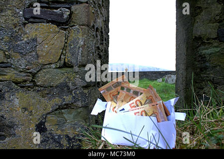 50 Euro in einem Briefumschlag an das Gras Stockfoto