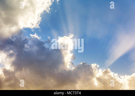 Sonne hinter pulsierenden bunten Wolken und Sonnenstrahlen in den blauen Himmel mit Kopie Raum, inspirierenden Hintergrund Stockfoto