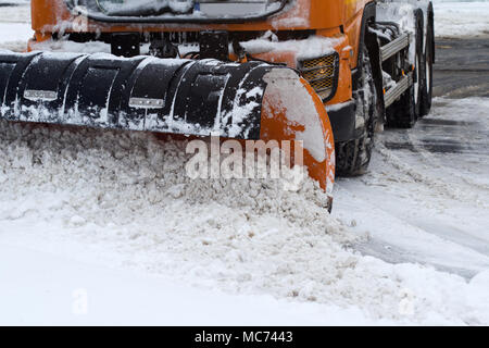 Vorderansicht eines Orange Snow plug Arbeiten auf einer Straße der Stadt Stockfoto