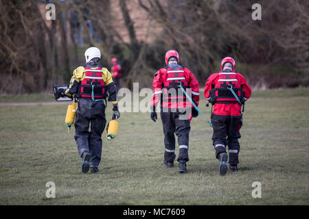 Die Feuerwehrleute bei einem Fluss Rettungsaktion jemand aus dem Wasser ziehen. Stockfoto