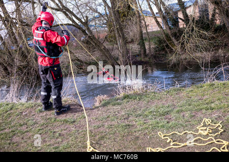 Die Feuerwehrleute bei einem Fluss Rettungsaktion jemand aus dem Wasser ziehen. Stockfoto