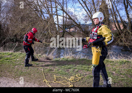 Die Feuerwehrleute bei einem Fluss Rettungsaktion jemand aus dem Wasser ziehen. Stockfoto