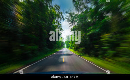 Ansicht von der Vorderseite des blauen Auto auf Asphalt und Geschwindigkeit Bewegungsunschärfe auf der Autobahn im Sommer mit grünen Bäumen, Wald, auf dem Land Stockfoto