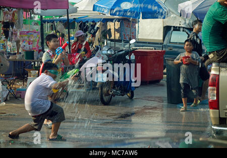 Songkran Tag 2018, Thai Neujahr, junger Mann, Wasserpistole, an Personen, die in einem Pickup Truck, Kinder werfen und Spritzwasser, Posri Straße, Udon Thani, Isaan, Thailand Stockfoto