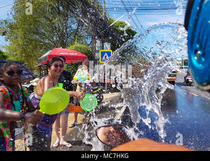 Phuket, Thailand - 13. April 2018: die Masse der Leute gießen Sie Wasser auf Motorrad fahrer Feiern traditionelle thailändische Neujahr Songkran Festival. Credit: Anna Moskvina/Alamy leben Nachrichten Stockfoto