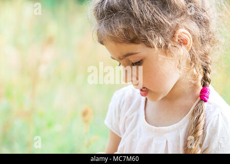 Süße kleine Mädchen spielt mit auf einer Wiese an einem sonnigen Sommertag. Stockfoto