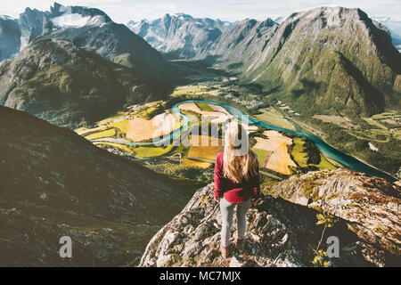 Reisende Mädchen stehen auf Klippe über Berge Tal Reisen solo Abenteuer Lifestyle aktive Ferien in Norwegen Luftaufnahme Stockfoto