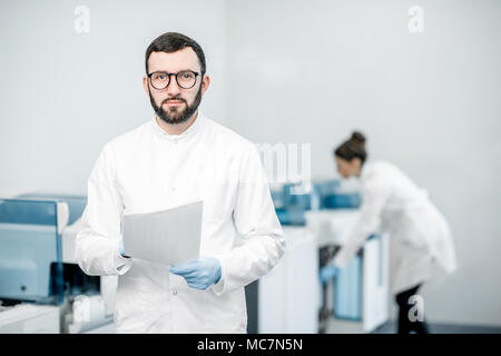 Mann mit Frau Techniker expertising Analyzer Maschine im Labor Stockfoto