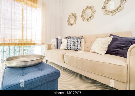 Wohnzimmer mit einem bequemen Sofa, das sich in moderne und luxuriöse Apartment am Nachmittag Sonne beleuchtet Stockfoto