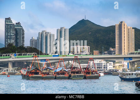 Fischtrawler in Hongkong Aberdeen Bay. Verkehr Brücke, Gebäude, Wolkenkratzer im Hintergrund. Stadt Geometrie und Südostasien schöne Natur Stockfoto