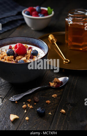 Frisches Müsli, Müsli mit Joghurt, Blaubeeren, Himbeeren, getrocknete Apfel und Preiselbeeren mit Chia Samen. Frischer gemischter Beerenfrucht und Ahornsirup. Stockfoto