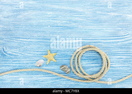 Marine Steine und Muscheln, Seil auf alten Blau lackiert Holzbretter Stockfoto