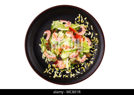 Meeresfrüchte Salat. Lecker Salat mit Garnelen und Gemüse und Algen Chukka, gekleidet mit Soße auf einer schwarzen Platte. Salat in eine Platte isoliert auf weißem backgro Stockfoto