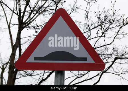 Höcker im Straßenverkehr Warnung rotes Dreieck Schild auf metallpfosten mit Baum verzweigt sich der Fokus in den Hintergrund. Stockfoto