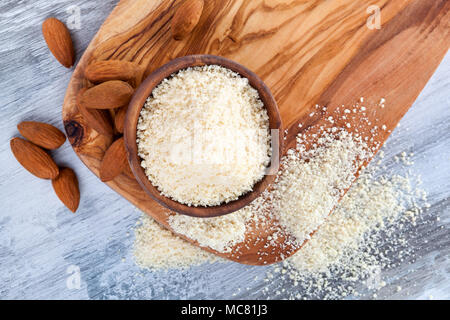 Glutenfreie Mandeln Mehl in Houten mit Mandeln von oben auf Holztisch. Zöliakie Konzept. Stockfoto