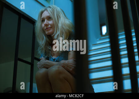 Reife Frau sitzt auf der Treppe, auf der Suche in Gedanken Stockfoto
