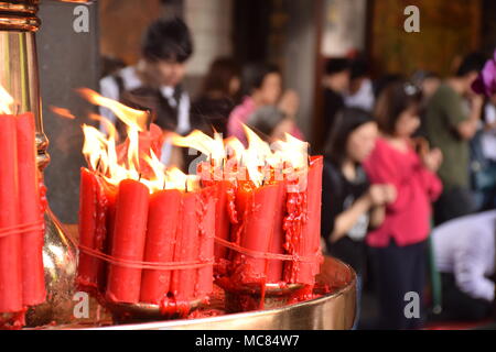 Rote Kerzen mit unscharfen Leute im Hintergrund innen Longhsan buddhistischen Tempel beten in Taipei, Taiwan Stockfoto