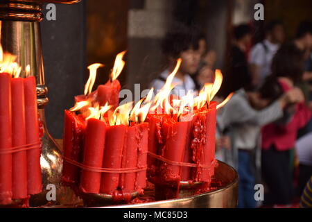 Rote Kerzen mit unscharfen Leute im Hintergrund innen Longhsan buddhistischen Tempel beten in Taipei, Taiwan Stockfoto