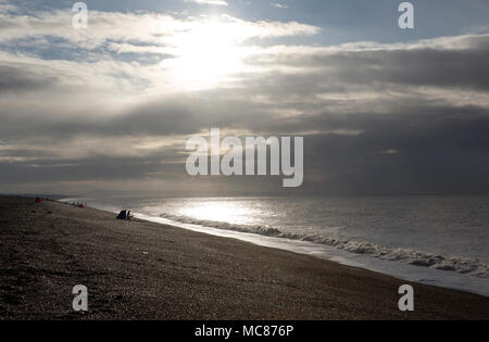 Strand angler angeln am Chesil Beach, nach einem Sturm im Januar 2018. Angeln nach einem Sturm eine produktive Zeit sein kann, für einen Fisch, um zu versuchen Stockfoto