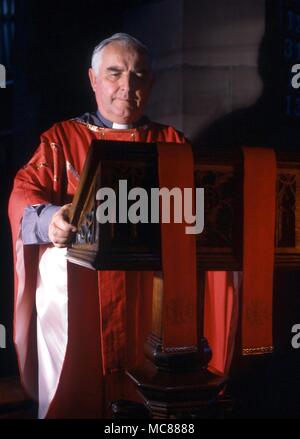 CHRISTIAN anglikanische Priester Lesung aus der Heiligen Schrift an einem Rednerpult Stockfoto